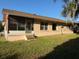 Exterior shot of a home with a screened-in porch, backyard grass, and windows at 616 Water Rd, Ocala, FL 34472
