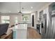 A bright kitchen with stainless steel appliances, white cabinets, a center island, and wood flooring at 6557 Se 4Th Ln, Ocala, FL 34472