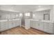 A luxurious bathroom featuring double vanities, a shower, and wood floors at 7199 Sw 60Th Ln, Ocala, FL 34474