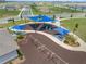 Aerial view of a modern playground with slides, swings, picnic tables, and sunshades for a comfortable experience at 7199 Sw 60Th Ln, Ocala, FL 34474