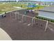 An aerial shot shows a swing set and a play area in a community park with other various playground equipment at 7199 Sw 60Th Ln, Ocala, FL 34474