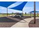Wide angle view of a playground featuring slides and picnic tables, covered by sunshades at 7199 Sw 60Th Ln, Ocala, FL 34474