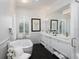 Bright bathroom featuring double sinks, marble floors, a soaking tub, and elegant fixtures under a crystal chandelier at 8033 Nw 29Th Street Rd, Ocala, FL 34482
