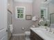 Modern bathroom with a glass shower, decorative mirror and wood vanity next to a window overlooking the property at 8033 Nw 29Th Street Rd, Ocala, FL 34482