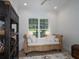 Cozy bedroom featuring a decorative wicker sofa and a well-lit window overlooking the property's exterior at 8033 Nw 29Th Street Rd, Ocala, FL 34482