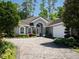 A beautiful single-story home with arched windows, a tile roof, and a paved driveway at 8033 Nw 29Th Street Rd, Ocala, FL 34482
