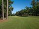 Expansive golf course view, with lush greenery and mature trees on a sunny day at 8033 Nw 29Th Street Rd, Ocala, FL 34482