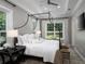 Serene main bedroom with a four-poster bed, tray ceiling, and ample natural light at 8033 Nw 29Th Street Rd, Ocala, FL 34482