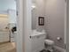 Stylish powder room featuring modern fixtures, a vanity, a sink, and a toilet, next to the laundry room at 8033 Nw 29Th Street Rd, Ocala, FL 34482