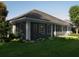 Screened in porch with a tile roof, gray exterior and view of the landscaped yard at 8033 Nw 29Th Street Rd, Ocala, FL 34482