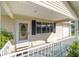 Charming front porch with white railing, front door with glass detail, and view of attached garage at 8375 Sw 109Th Lane Rd, Ocala, FL 34481