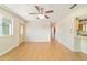 Spacious living room with wood floors and a ceiling fan, featuring a view of the kitchen at 8375 Sw 109Th Lane Rd, Ocala, FL 34481