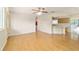 Bright living room with wood floors, ceiling fan, and an open layout to the kitchen at 8375 Sw 109Th Lane Rd, Ocala, FL 34481