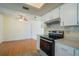 Bright kitchen and dining area featuring white cabinets, hardwood floors and stainless steel oven at 8463 Sw 108Th Pl, Ocala, FL 34481