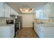 Well-lit kitchen with white cabinets, stainless steel appliances, and a ceiling fan at 8463 Sw 108Th Pl, Ocala, FL 34481