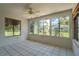 Bright sunroom with neutral tile, ceiling fan, and large windows showcasing the backyard at 8463 Sw 108Th Pl, Ocala, FL 34481