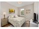 Bright bedroom with a floral bedspread, colorful artwork, and a large window at 8820 Sw 58Th Street Rd, Ocala, FL 34481