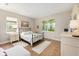 Sunlit bedroom with hardwood floors, neutral paint, a wrought iron bed, and two windows at 8820 Sw 58Th Street Rd, Ocala, FL 34481