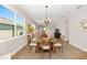 Cozy dining area featuring a wooden table and chairs, chandelier, and natural light from large windows at 8820 Sw 58Th Street Rd, Ocala, FL 34481