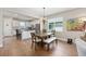 Open dining area featuring wood floors, chandelier, and views into a modern kitchen with stainless steel appliances at 8820 Sw 58Th Street Rd, Ocala, FL 34481
