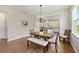 Bright dining area with a wooden table, bench seating, chandelier, and view to outdoor patio at 8820 Sw 58Th Street Rd, Ocala, FL 34481