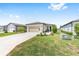 Inviting single-story home with a well-kept lawn and long driveway leading to a two-car garage at 8820 Sw 58Th Street Rd, Ocala, FL 34481
