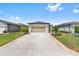 Attractive one-story home featuring a manicured lawn, a two-car garage, and a paved driveway at 8820 Sw 58Th Street Rd, Ocala, FL 34481