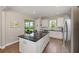 Bright kitchen featuring a large island, stainless steel appliances, and backyard access at 8820 Sw 58Th Street Rd, Ocala, FL 34481