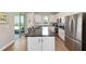 Open kitchen with stainless steel appliances, a large island, and access to a screened lanai at 8820 Sw 58Th Street Rd, Ocala, FL 34481
