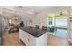 Kitchen island with a dark countertop, white cabinets, and bar stool seating with access to a patio at 8820 Sw 58Th Street Rd, Ocala, FL 34481