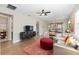 Open-concept living room with wood floors, ceiling fan, and a view into the kitchen at 8820 Sw 58Th Street Rd, Ocala, FL 34481