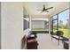 Screened-in patio with a ceiling fan and comfortable seating with views of the yard at 8820 Sw 58Th Street Rd, Ocala, FL 34481