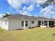 Image showcases the rear of the house, highlighting the screened-in patio and the yard at 9029 Se 135Th Loop, Summerfield, FL 34491