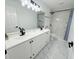 Modern bathroom featuring double sinks, granite counters, and a marble tile shower at 9029 Se 135Th Loop, Summerfield, FL 34491