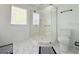 Bright bathroom featuring shower, glass door, and white tiled floor at 9029 Se 135Th Loop, Summerfield, FL 34491