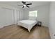 Bright bedroom with wood floors, a ceiling fan, and a large window for natural light at 9029 Se 135Th Loop, Summerfield, FL 34491