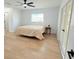 Bright bedroom with light wood floors, fan and window at 9029 Se 135Th Loop, Summerfield, FL 34491