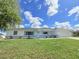 Single-story home with beautiful lawn, freshly painted white exterior, and blue shutters at 9029 Se 135Th Loop, Summerfield, FL 34491