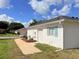 Image showing the side of the house, featuring the garage and white exterior with blue accents at 9029 Se 135Th Loop, Summerfield, FL 34491