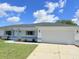 Charming single-story home featuring a two-car garage and well-maintained front lawn at 9029 Se 135Th Loop, Summerfield, FL 34491