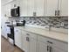 Contemporary kitchen design with white cabinets, stainless steel appliances, and stylish backsplash at 9029 Se 135Th Loop, Summerfield, FL 34491
