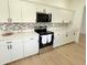 Well-appointed kitchen with white cabinetry, stainless steel oven and plentiful counter space at 9029 Se 135Th Loop, Summerfield, FL 34491