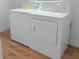 Bright laundry room with a new white washer and dryer set on wood-look floors at 9029 Se 135Th Loop, Summerfield, FL 34491