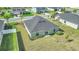 Backyard view of the home showing the well-kept lawn, simple landscaping, and privacy fence at 9266 Sw 58Th Cir, Ocala, FL 34476