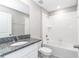 Bright bathroom features a granite countertop vanity and tiled shower-tub combination at 9266 Sw 58Th Cir, Ocala, FL 34476