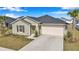Well-kept single-story home showcasing an attached two-car garage and a simple, landscaped front yard under a bright sky at 9266 Sw 58Th Cir, Ocala, FL 34476
