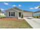 Single-story home featuring a two-car garage, front yard landscaping, and a neutral exterior at 9266 Sw 58Th Cir, Ocala, FL 34476