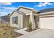 Close-up of a cozy home's entrance featuring neutral siding, a well-manicured landscape, and a convenient two-car garage at 9266 Sw 58Th Cir, Ocala, FL 34476