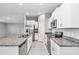 Kitchen featuring granite countertops, stainless steel appliances, and white cabinets provides a modern aesthetic at 9266 Sw 58Th Cir, Ocala, FL 34476
