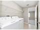 Well-lit laundry room features a modern washer and dryer, and convenient shelving for storage at 9266 Sw 58Th Cir, Ocala, FL 34476